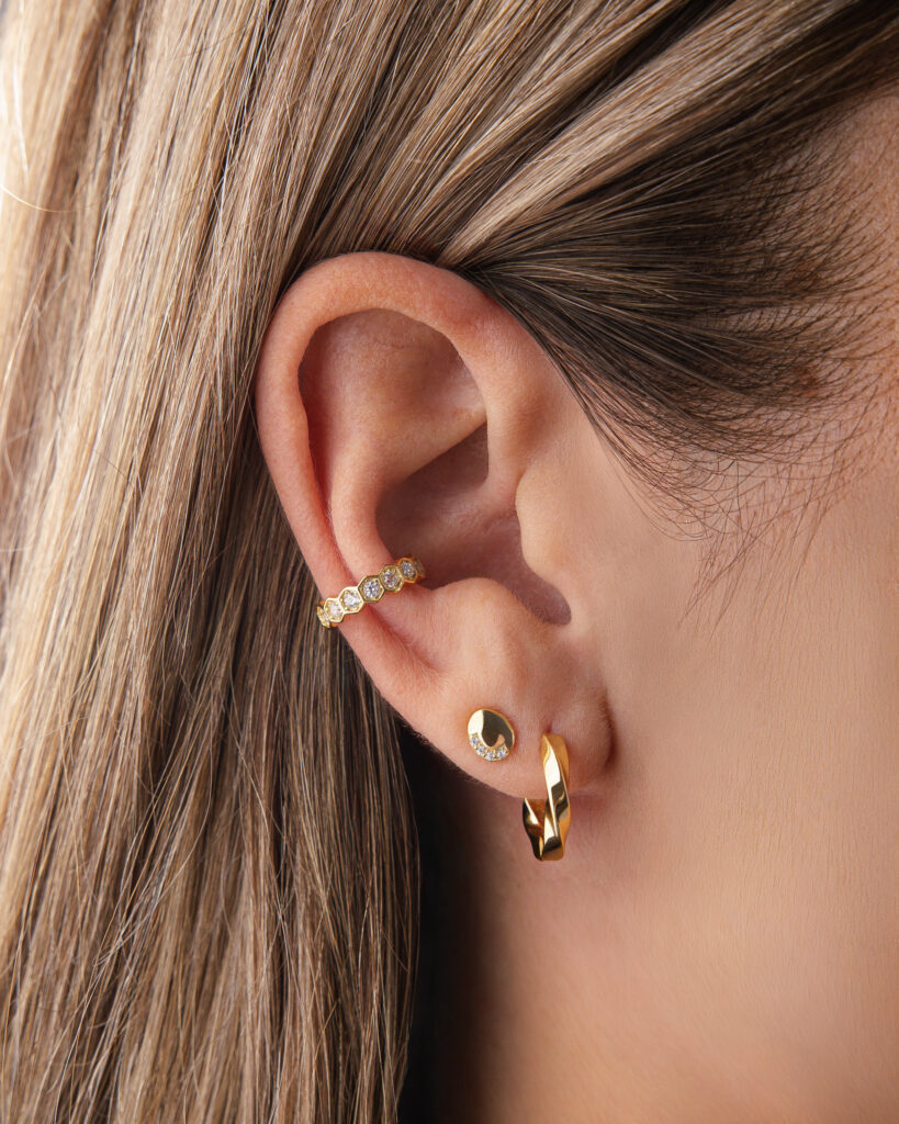 Earcuff NYRA doré en argent 925 plaqué or, serti de zircones sur fond blanc