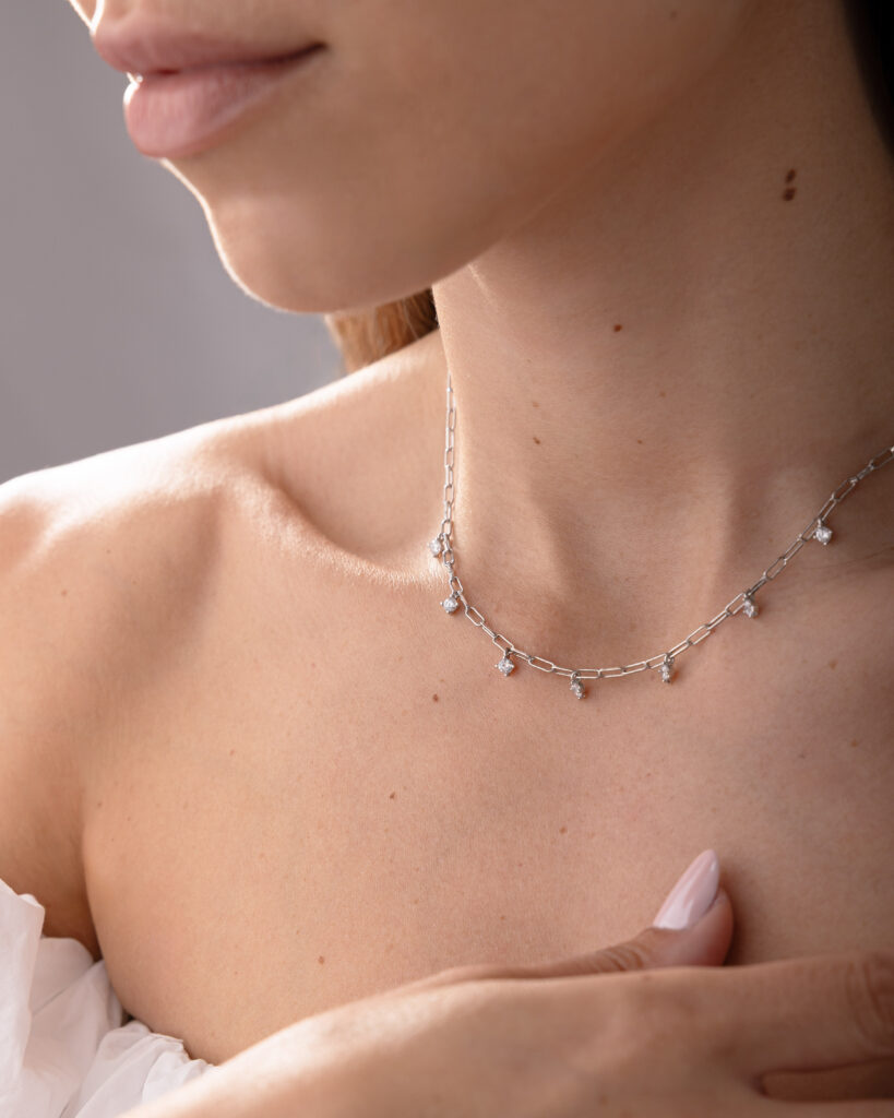 Collier NOXY en argent sterling 925, disponible en finition argentée ou dorée, orné de zircones blanches suspendues.