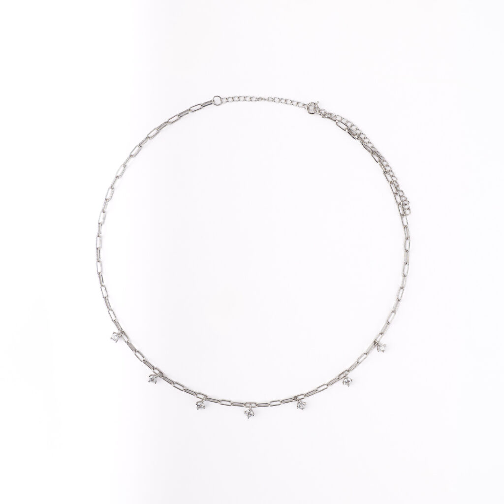 Collier NOXY en argent sterling 925, disponible en finition argentée ou dorée, orné de zircones blanches suspendues.