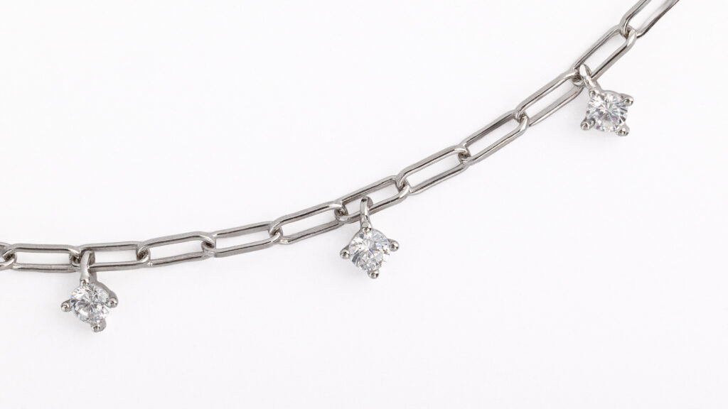 Collier NOXY en argent sterling 925, disponible en finition argentée ou dorée, orné de zircones blanches suspendues.